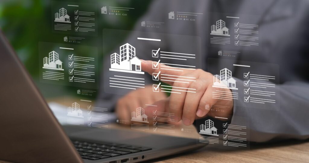 Personne travaillant sur un ordinateur, et comparant des biens immobiliers.