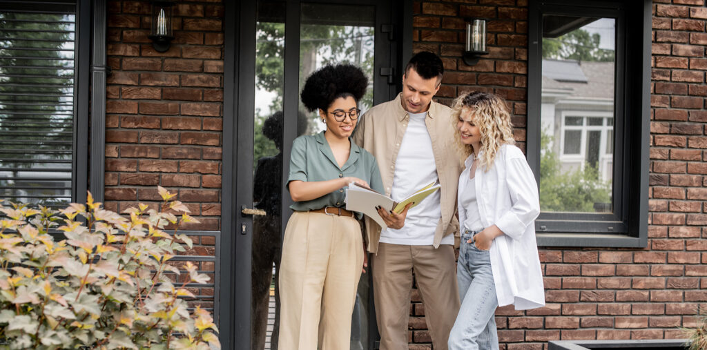 Couple visitant un bien immobilier avec un agent immobilier.