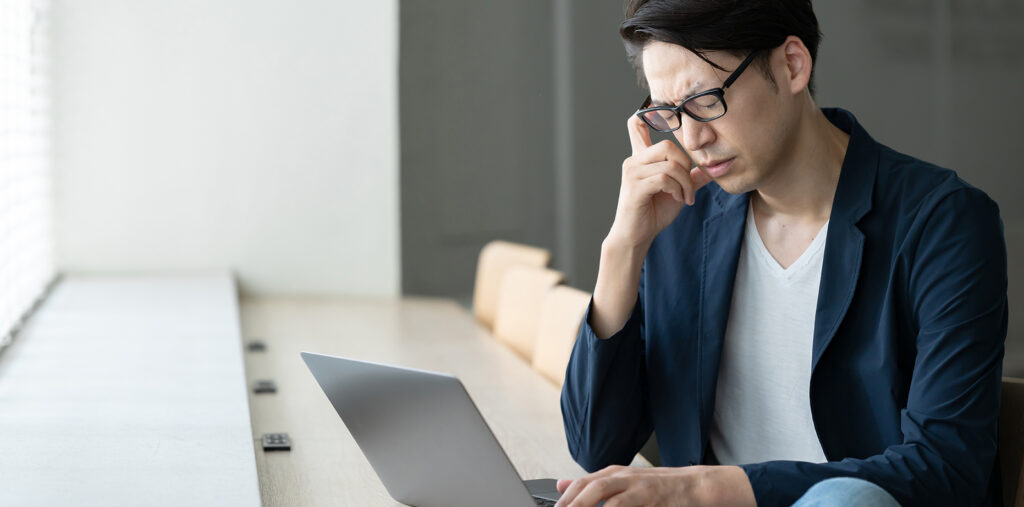Homme fatigué travaillant sur un ordinateur